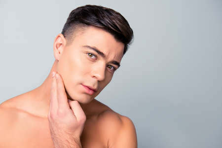 Close up portrait of satisfied confident handsome guy touching with shaved flawless clean soft skin after morning shaving, isolated on grey background, copy-spaceの写真素材
