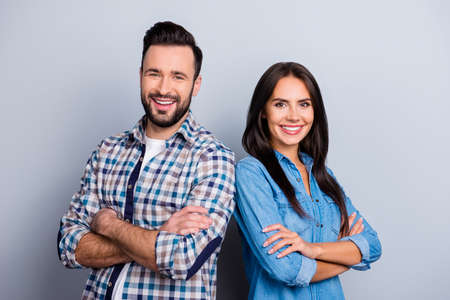 He vs She portrait of caucasian, hispanic couple in shirts - man with bristle and pretty, charming woman with crossed hands standing over grey backgroundの写真素材