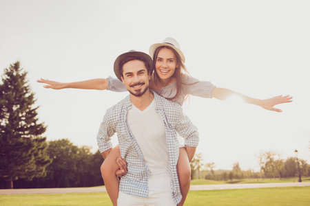 Date outside, well dressed, excited, lovely. Good day, happiness, friendship, stroll, holiday, fly, freedom concept. Cute sweet partner piggybacking his lady, she rides himの写真素材