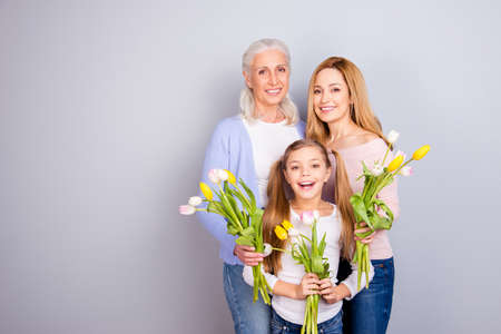 People weekend joy leisure lifestyle motherhood parenthood maternity mama mommy concept. Portrait of adorable sweet gentle lovely beautiful three women standing together isolated on gray backgroundの写真素材