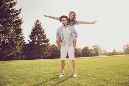 Cute sweet partner piggybacking his lady, she rides him. Date outside, well dressed, excited,...