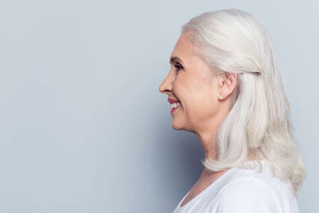 Close up profile, half face portrait with copy space of cheerful, happy, aged, mature, nice woman  ...