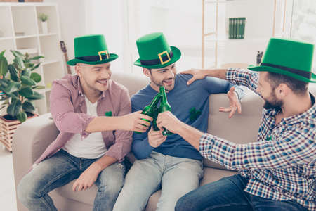 Happy Saint Patrick's day! Portrait of successful, confident, handsome, attractive guys sitting on...