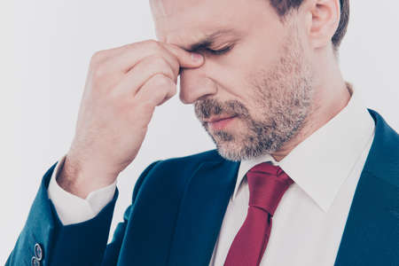 Cropped close up photo of sad upset nervous freelancer with closed eyes suffering from headache wearing red tie white shirt touching nose-bridgeの写真素材