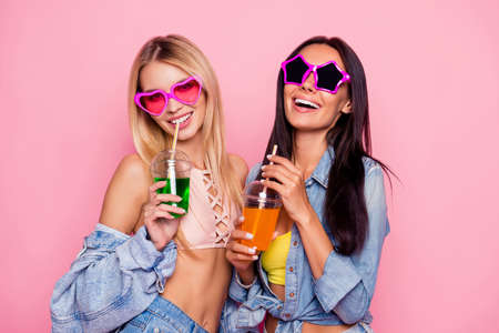 Cheerful, charming, positive, laughing, comic girls in summer heart and star shape glasses, jeans...