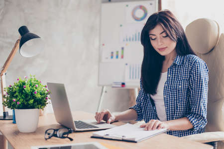 Confident concentrated pretty agent controlling the document on table searching in netbookの写真素材