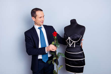 Portrait of strange handsome lovely guy holding blossom isolated on gray backgroundの写真素材