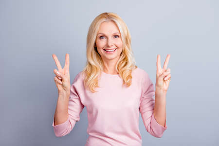 Portrait of cheerful excited friendly beautiful pretty cute lovely senior lady making v-signs...