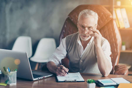 Portrait of smart intelligent handsome entrepreneur holding pen signing partnership contractの写真素材