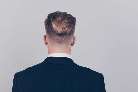 Behind rear back view photo of handsome attractive serious agent marketer staying straight wearing black dark blazer white collar isolated on gray background copy-spaceの写真素材