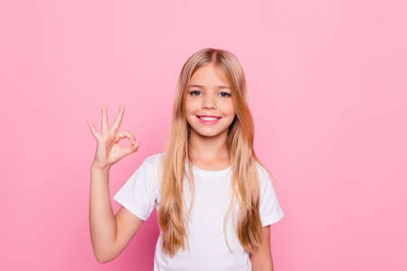 Elementary dream dreamy perfect excellent studying learning concept. Portrait of cute lovely beautiful adorable sweet with beaming smile in white tshirt girl making ok symbol isolated pink backgroundの写真素材