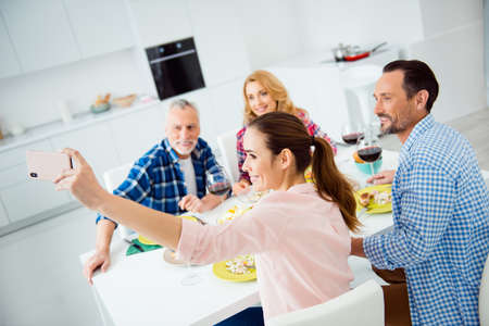Beautiful, attractive, cheerful women shooting self portrait on smart phone with her relatives,...