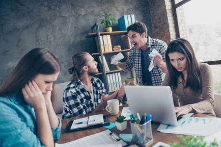 Tired aggressive unsatisfied angry mad crazy colleagues are having scandal at workstation and...