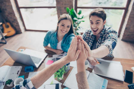 Cheerful, excited, joyful people sitting in work place, station, making palms clasped, handshake,...