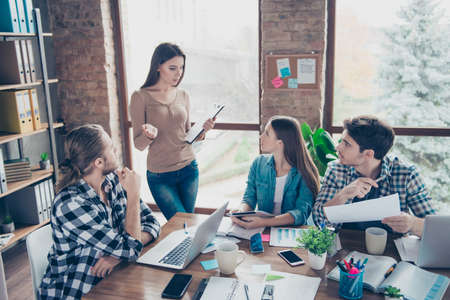 Portrait of beautiful attractive woman teaching explaining to her attentive listeners, friends material, plan, strategy in workplace, workstation, holding using clipdoard computer, laptopの写真素材