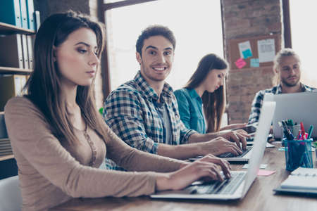 Attractive, smiling, stylish man in checkered shirt working, expertising together with his...