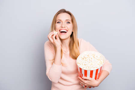 Portrait of relaxed carefree rejoicing beautiful excited cheerful joyful spectator watching film isolated on gray backgroundの写真素材