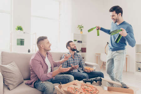 Portrait of stylish, attractive, positive guys in casual outfit eating snack, food, greeting his...