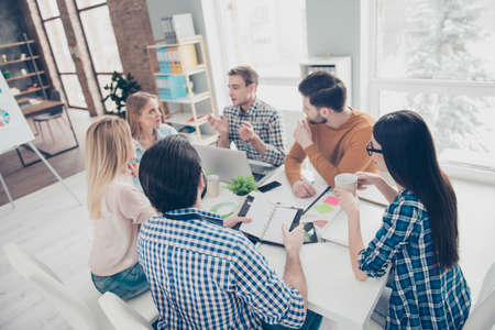 Stylish, attractive, confident, executive, corporate, serious, attentive, concentrated business people in modern station with interior listening plans strategy of their partner during coffee breakの写真素材