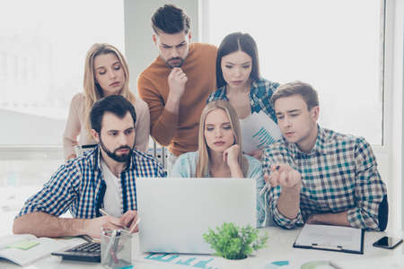 Attractive, stylish, smart experts financiers in casual outfits trying to find solution, decision, solving problem, developing, preparing project, start up, presentation, planning new strategyの写真素材