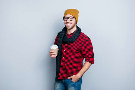 It's cold outside! Trendy fashionable handsome attractive stylish masculine virile guy dressed in casual outfit and glasses enjoying fresh aromatic tea, isolated on gray backgroundの写真素材