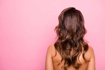Portrait with copy space, rear view of young, sexy, pretty, attractive, naked, shirtless girl with curly, perfect, ideal hair, isolated on pink backgroundの写真素材