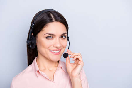 Portrait with copy space of cheerful pretty charming half turned woman in shirt with headset holding...