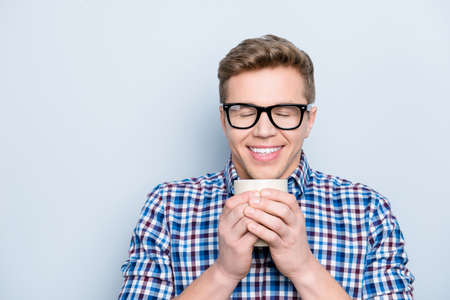 Aromatic university person delight pleasure concept. Close up portrait of rejoicing funny funky cheerful joyful cute lovely guy drinking fresh tasty coffee isolated on gray background copy-spaceの写真素材