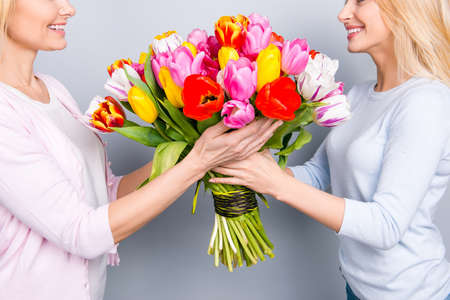 Cropped close up half face portrait, two cheerful woman, nice girl giving big colorful seasonal...
