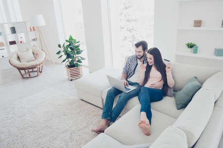 Portrait of clients, trendy shopaholics, modern couple having plastic credit discount card in hand...