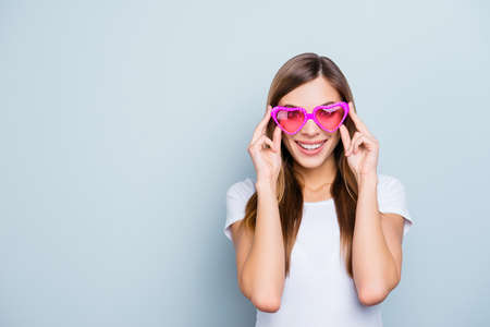 Portrait with copyspace, empty place of funky pretty girl looking at life through pink glasses in...