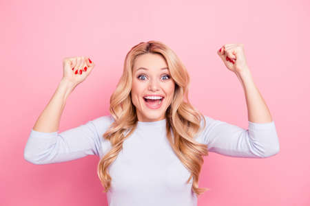 Sale! Portrait of glad student, funny girlfriend, foolish freelancer, comic girl with arms up celebrating victory, yelling with wide open mouth isolated on pink backgroundの写真素材
