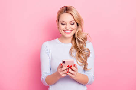 Portrait of pretty charming girl with modern hairdo having cellphone, smart phone in hands checking...