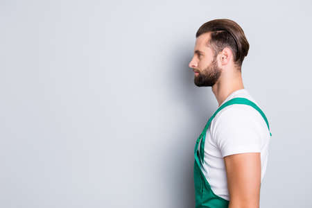 Profile side view portrait with copyspace, empty place for advertisement, product of calm attractive cleaner with stubble, hairstyle in uniform, isolated on grey backgroundの写真素材