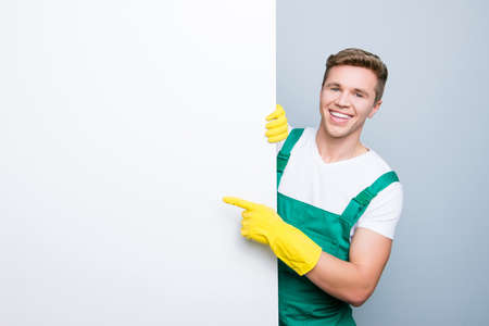 Text people sheet place billboard attention look tips people personnel hotel dust purity white wall face peep person concept. Glad polite kind man suggesting to use isolated on gray backgroundの写真素材