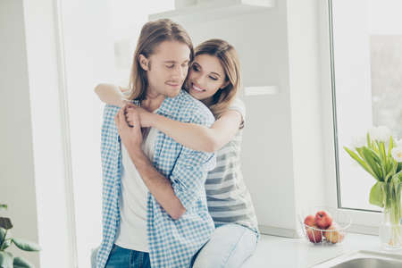 He vs she together forever!Portrait of stylish lovely partners in casual outfis embracing in kitchen in the morning. Lovestory conceptの写真素材