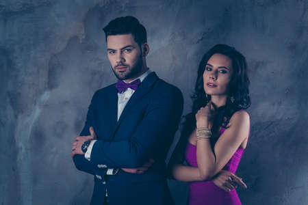 Portrait of harsh virile man with bristle in suit tux with bow and attractive charming woman with...