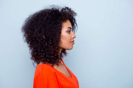 Profile portrait of charming pretty woman with modern hairdo in orange outfit isolated on grey...