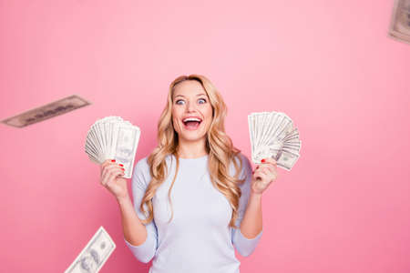 Wow, omg! Portrait of impressed glad  girl having a lot of flying money around her, having...