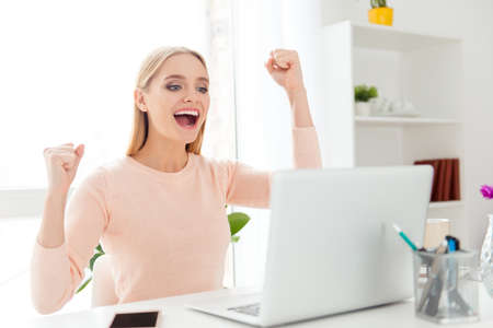 Portrait of cheerful positive girl celebrating successfully pass exams with raised fists looking at...