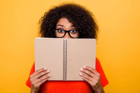 WTF! Portrait of impressed funny girl looking out organizer with wide open eyes isolated on bright...