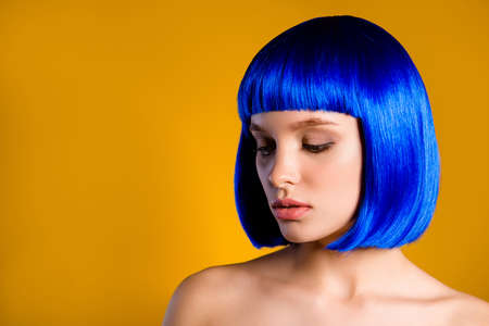 Portrait with copyspace empty place for product of pop exotic girl in blue wig having natural make up isolated on yellow background. Hair care haircare hairdo conceptの写真素材
