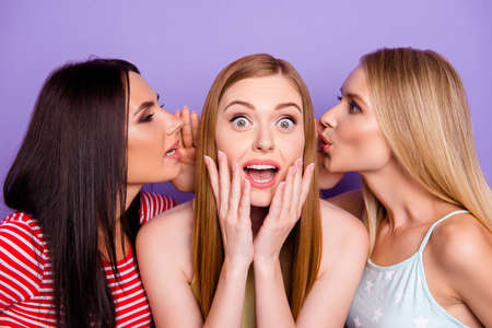 Portrait of astonished girl with wide open eyes mouth listening gossips on two ears from friends isolated on vivid violet backgroundの写真素材