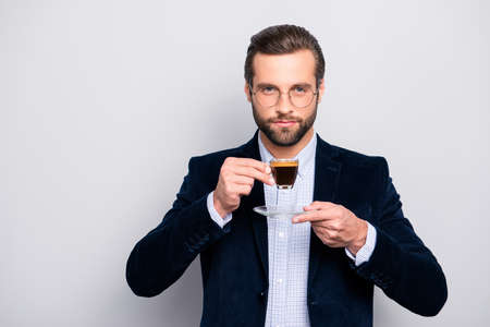 Portrait of chic handsome pleased delightful serious attractive dreamy wealthy elegant classy man smelling the aroma of fresh bitter coffee isolated on gray background copy-spaceの写真素材