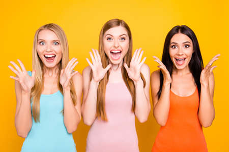 Portrait of mad funny girls yelling with wide open mouth full of happiness gesturing with palms...