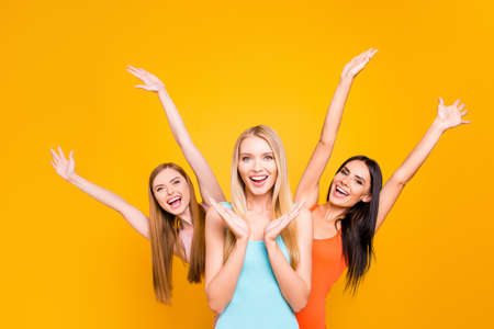 Portrait of playful foolish girls making surprise enjoying time together holding raised arms...