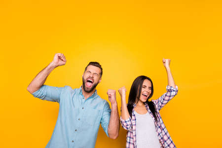 Portrait of crazy man couple full of happiness yelling loudly holding raised arms keeping eyes...