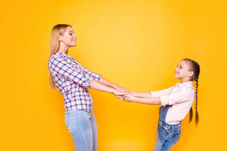 Whirl round freedom carefree weekend spend time together concept.  Portrait of two pretty joyful excited rejoicing cute sweet girls gripping palms looking at each other isolated on bright backgroundの写真素材