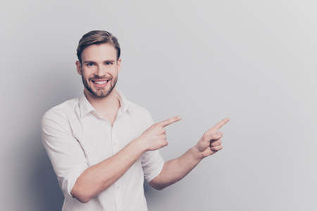 Look attention ! Leave your feedback here! People service tips concept. Portrait of confident excited handsome experienced manager pointing on empty blank place text isolated gray background copyspaceの写真素材