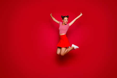 Full-length full-size view of jumping laughing and happy woman dressed in colourful bright clothes...